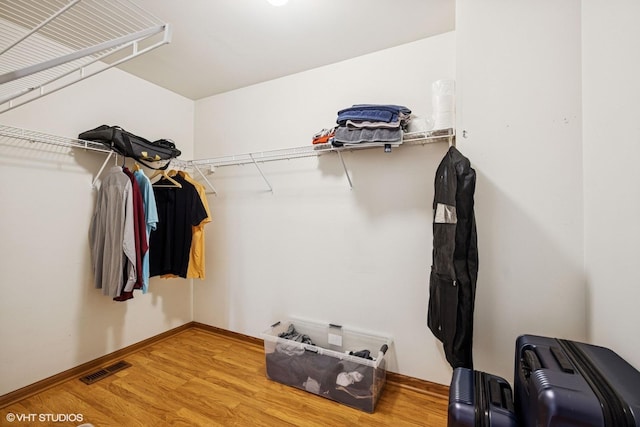 walk in closet with wood finished floors
