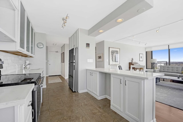 5455 N Sheridan Rd Unit 2915, Chicago, IL 60640 - kitchen featuring stainless steel range with electric cooktop, freestanding refrigerator, open floor plan, backsplash, and a peninsula
