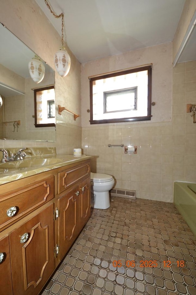 2820 S Shields Ave, Chicago, IL 60616 - bathroom featuring tile walls, vanity, a bathtub, and toilet