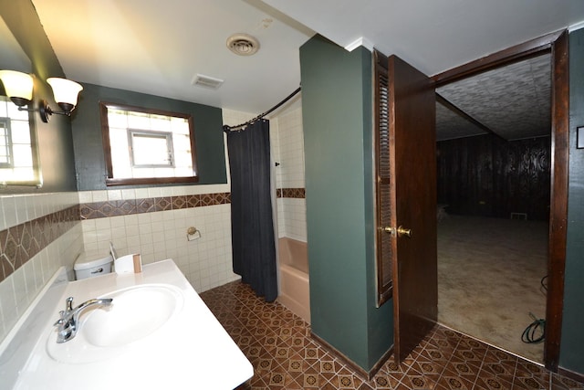2820 S Shields Ave, Chicago, IL 60616 - full bathroom featuring a sink, a chandelier, tile walls, shower / tub combo with curtain, and wainscoting