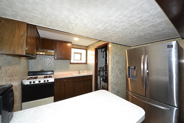 2820 S Shields Ave, Chicago, IL 60616 - kitchen with stainless steel fridge with ice dispenser, range with gas cooktop, under cabinet range hood, and light countertops