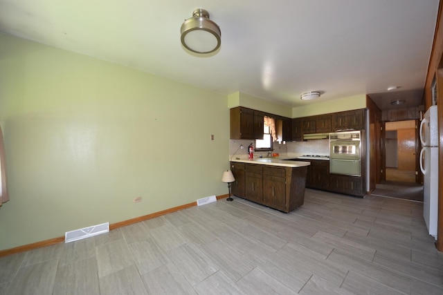 2820 S Shields Ave, Chicago, IL 60616 - kitchen featuring a peninsula, light countertops, freestanding refrigerator, dark brown cabinetry, and baseboards