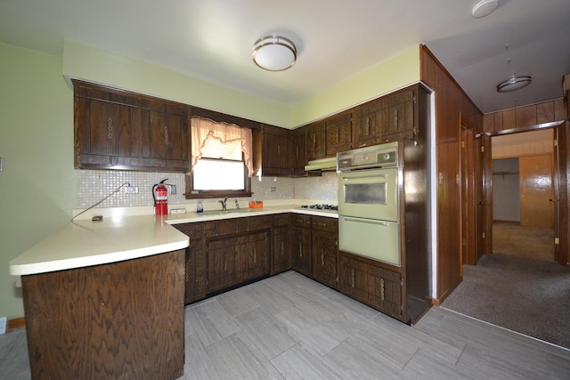2820 S Shields Ave, Chicago, IL 60616 - kitchen featuring a sink, light countertops, tasteful backsplash, stovetop, and dark brown cabinets