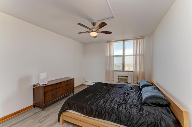 bedroom featuring a baseboard heating unit, an AC wall unit, baseboards, light wood finished floors, and ceiling fan