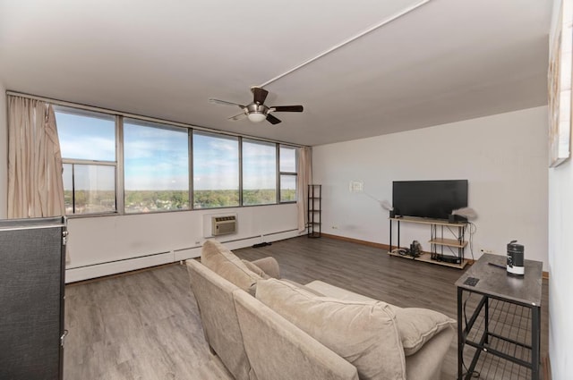 living area with wood finished floors, ceiling fan, plenty of natural light, and baseboard heating