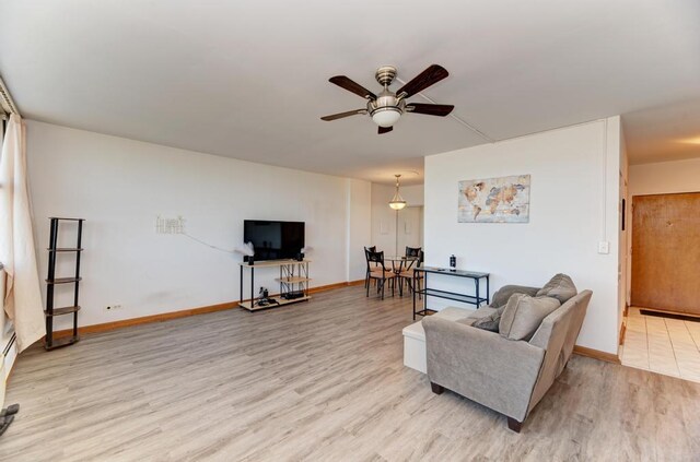 living area with ceiling fan, wood finished floors, and baseboards