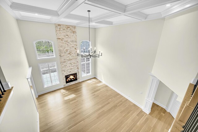1212 Georgias Way, New Lenox, IL 60451 - unfurnished living room with a high ceiling, wood finished floors, a stone fireplace, decorative columns, and stairway