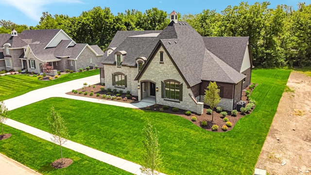 1212 Georgias Way, New Lenox, IL 60451 - french country home featuring stone siding, a shingled roof, a front lawn, and driveway