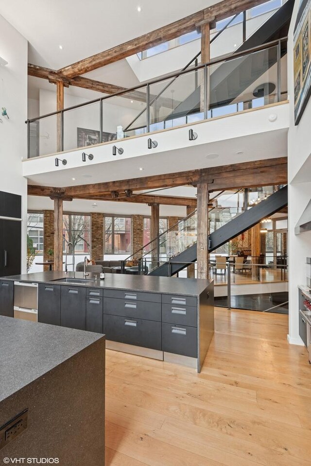 1804 N Leavitt St, Chicago, IL 60647 - kitchen with dark cabinetry, a sink, a towering ceiling, modern cabinets, and a spacious island