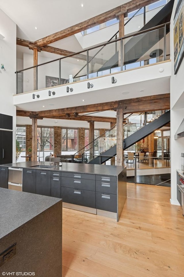 kitchen featuring a sink, dark cabinetry, a high ceiling, and modern cabinets