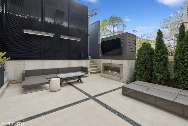 view of patio with a warm lit fireplace