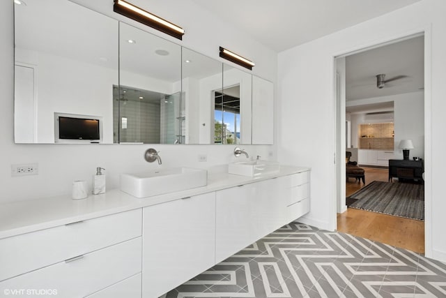 full bathroom featuring a shower stall, recessed lighting, double vanity, and a sink