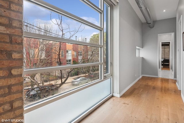 hallway featuring baseboards and wood-type flooring