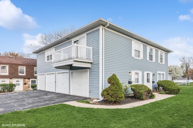 1387 Woodcutter Ln Unit D, Wheaton, IL 60189 - view of property exterior with a yard, driveway, an attached garage, and a balcony