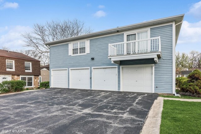 1387 Woodcutter Ln Unit D, Wheaton, IL 60189 - view of front facade featuring a garage, aphalt driveway, and a balcony