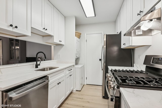 1387 Woodcutter Ln Unit D, Wheaton, IL 60189 - kitchen featuring a sink, stainless steel appliances, stacked washer / drying machine, under cabinet range hood, and light wood-style floors