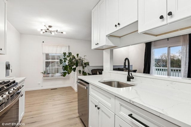 1387 Woodcutter Ln Unit D, Wheaton, IL 60189 - kitchen featuring a sink, stainless steel appliances, an inviting chandelier, light wood-style flooring, and white cabinetry