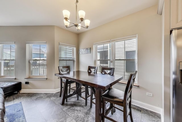 dining area with a chandelier, baseboards, and plenty of natural light