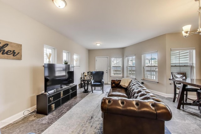 living room featuring a chandelier and baseboards