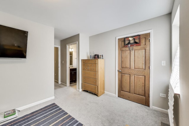 bedroom featuring carpet floors, baseboards, and connected bathroom