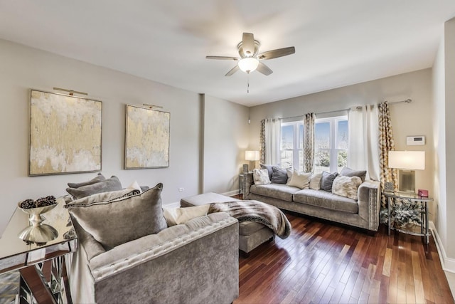 living area featuring a ceiling fan, dark wood-type flooring, and baseboards