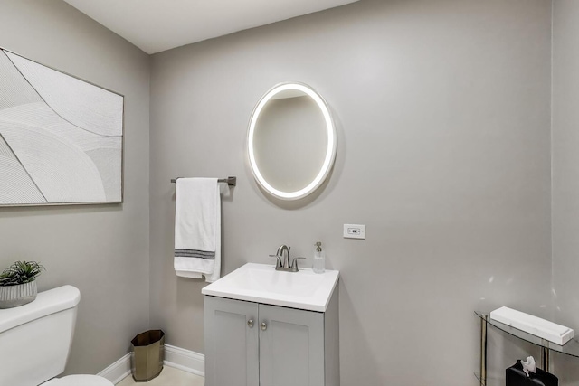 bathroom featuring toilet, baseboards, and vanity