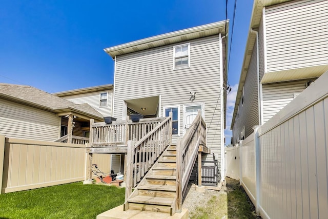 back of property featuring stairway, fence, and a deck
