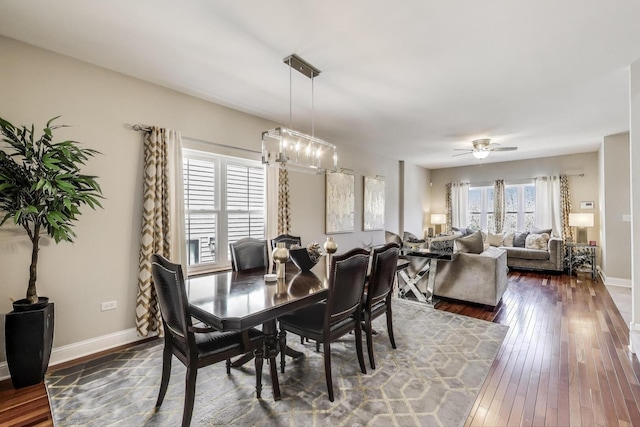 dining room featuring dark wood finished floors, baseboards, a chandelier, and ceiling fan