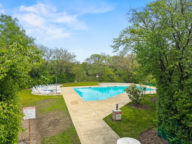 community pool with a lawn and a patio area