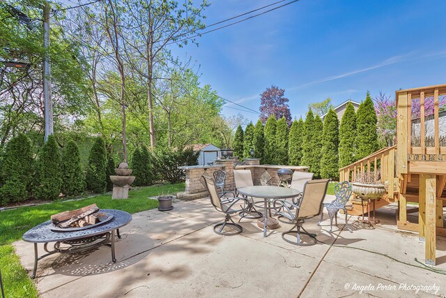 613 W Pheasant Ct, Round Lake Beach, IL 60073 - view of patio featuring a fire pit, a storage unit, an outbuilding, and outdoor dining space