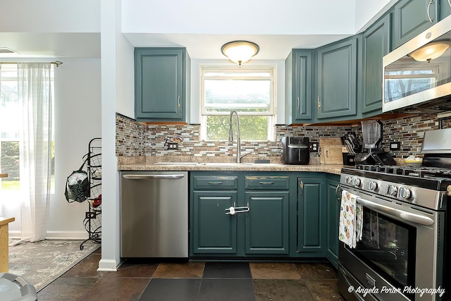 613 W Pheasant Ct, Round Lake Beach, IL 60073 - kitchen featuring appliances with stainless steel finishes, a sink, light countertops, and tasteful backsplash