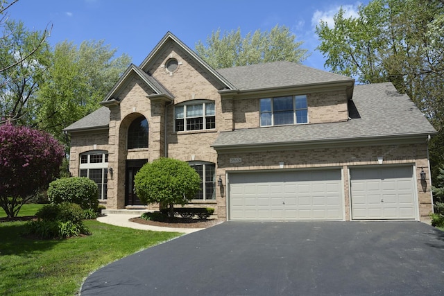 28W624 Berkshire Rd, West Chicago, IL 60185 - view of front of house featuring brick siding, asphalt driveway, a shingled roof, and a front yard