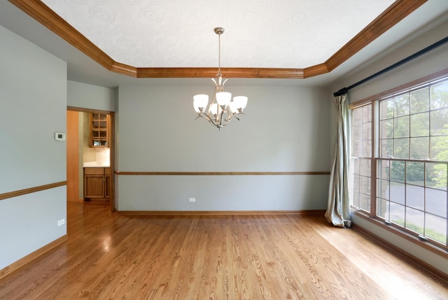 28W624 Berkshire Rd, West Chicago, IL 60185 - empty room featuring ornamental molding, a tray ceiling, light wood-type flooring, a chandelier, and plenty of natural light