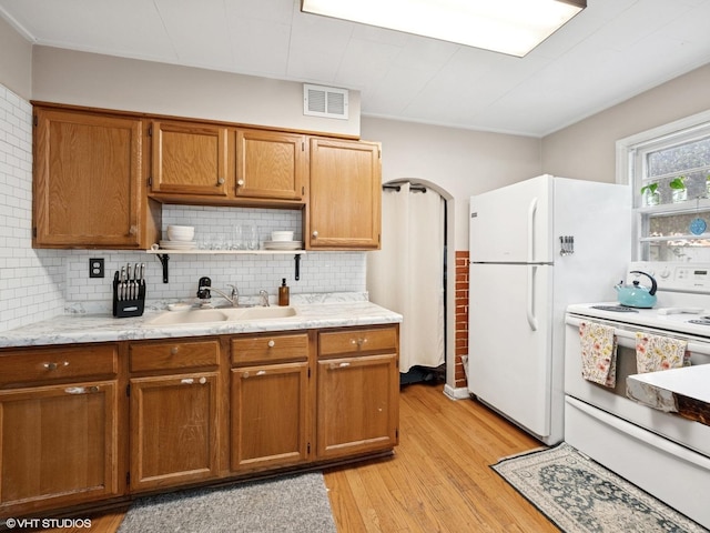 1345 Winaki Trl, Algonquin, IL 60102 - kitchen featuring white appliances, light wood-style floors, tasteful backsplash, a sink, and brown cabinetry