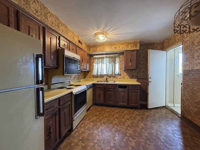 kitchen featuring freestanding refrigerator, electric stove, black microwave, light countertops, and dishwasher