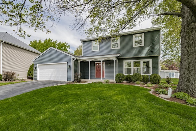 view of front of property with an attached garage, driveway, covered porch, and a front lawn