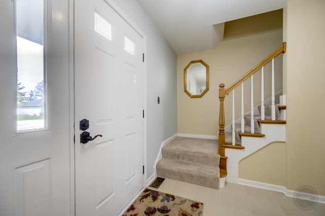 tiled entryway with stairway and baseboards