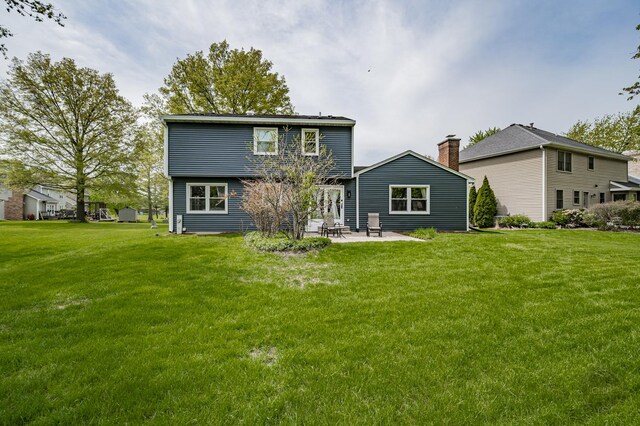 back of property with a patio area and a yard