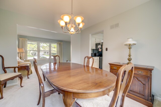 dining room featuring a chandelier and light colored carpet