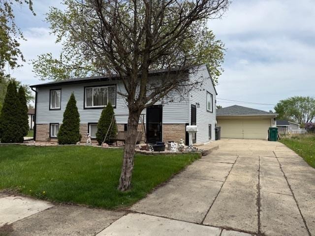 view of front of home featuring a front lawn, a detached garage, and an outbuilding