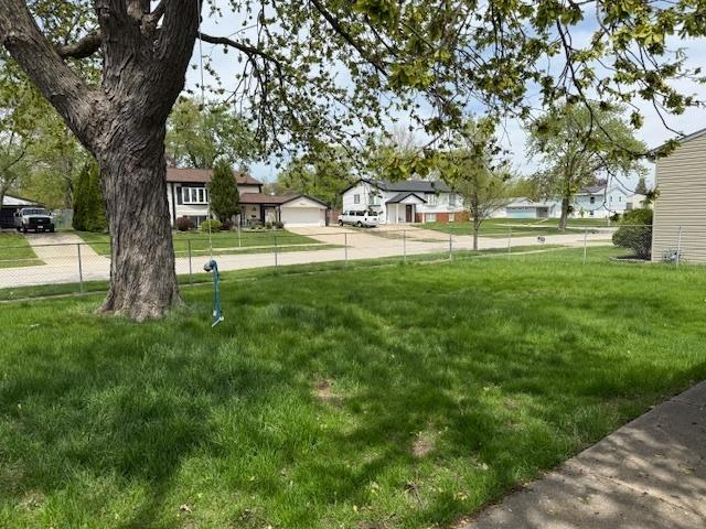 view of grassy yard with a residential view
