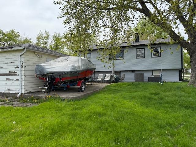 back of house featuring a lawn and a patio
