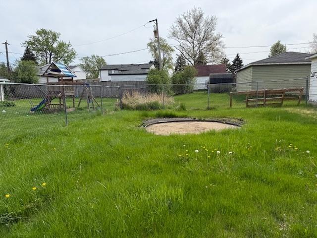 view of yard with a playground and fence