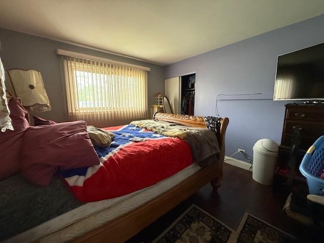 bedroom featuring a closet, wood finished floors, and vaulted ceiling