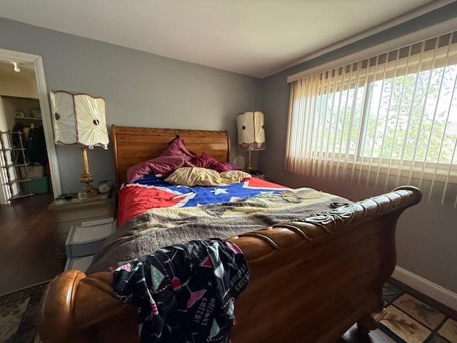 bedroom with wood finished floors and baseboards