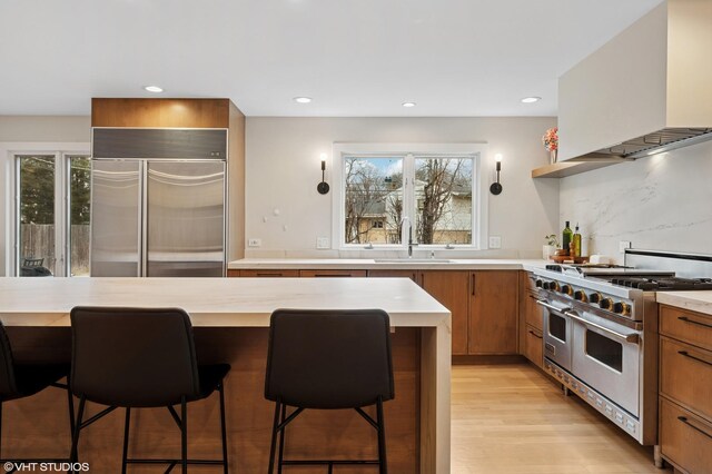 1115 Hunter Rd, Glenview, IL 60025 - kitchen with high quality appliances, extractor fan, light countertops, a sink, and brown cabinetry