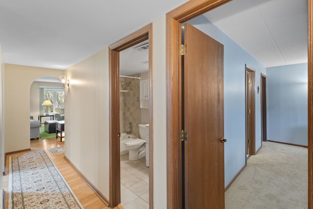 hallway featuring arched walkways and visible vents