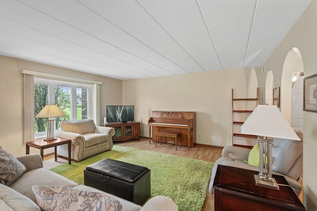 living room featuring arched walkways and wood finished floors