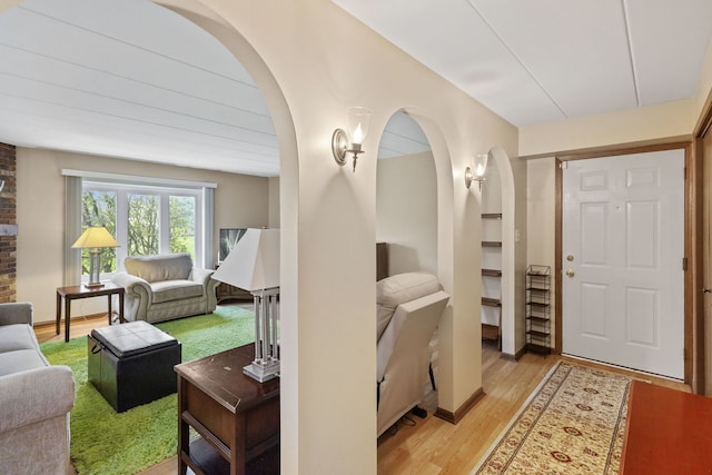 entrance foyer featuring light wood-style flooring and arched walkways
