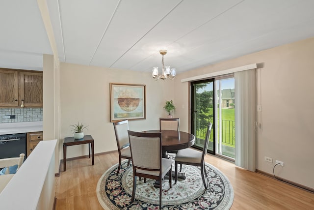 dining area with an inviting chandelier, light wood-style flooring, and baseboards